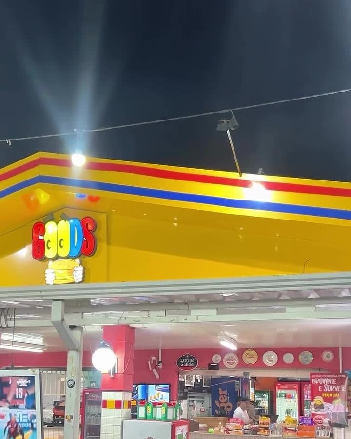 O telhado amarelo com o letreiro GOODS aceso sobre o balcão
